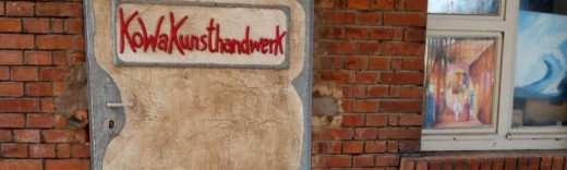 Metalltür in Ziegelmauer mit der Aufschrift "Kunsthandwerk KoWa"