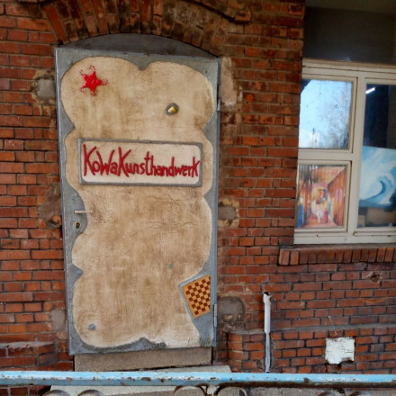 Metalltür in Ziegelmauer mit der Aufschrift "Kunsthandwerk KoWa"